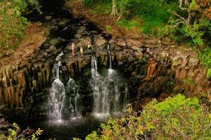 Family on the background of the Rochester waterfall on the island of Mauritius from a height.Waterfall in the jungle of the tropical island of Mauritius photo
