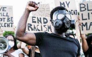 activista vistiendo gas máscara protestando en contra racismo y luchando para igualdad - negro vive importar demostración en calle para justicia y igual derechos - blm internacional movimiento concepto foto