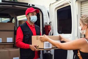 Delivery man wearing face protective mask to avoid corona virus spread - Young express courier delivering to costumer during coronavirus outbreak - Deliver and online buying concept photo