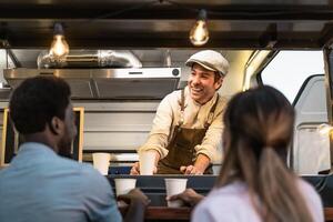 Happy multiracial people buying meal from street food truck market - Modern business and take away concept photo