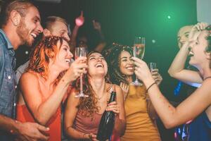 contento amigos haciendo fiesta Bebiendo champán en Club nocturno - grupo joven personas teniendo divertido celebrando nuevo año víspera Días festivos juntos en disco club - juventud cultura entretenimiento estilo de vida concepto foto