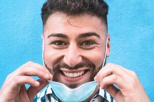 Young man portrait wearing surgical face mask - People using protective mask for preventing and stop corona virus spread - Healthcare and youth people during covid-19 outbreak concept photo