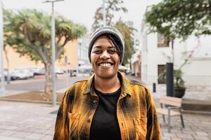 Happy African woman smiling in front of a camera in the city photo