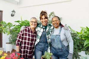 Happy multiracial women gardening together at home photo