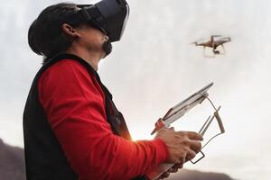 Male professional pilot doing fpv experience with virtual reality glasses and drone - Technology and innovation concept photo