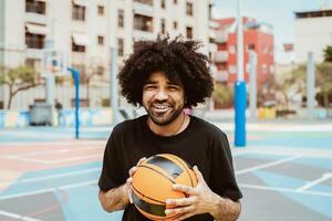 contento hombre jugando baloncesto al aire libre - urbano deporte estilo de vida concepto foto