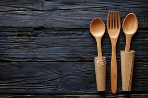 AI generated eco-friendly disposable tableware made of wood on a wooden background. the concept of recycling photo