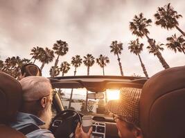 Happy senior couple having fun driving on new convertible car - Mature people enjoying time together during road trip tour vacation - Elderly lifestyle and travel culture transportation concept photo