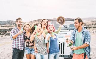 grupo de contento amigos haciendo fiesta en Desierto - viaje personas teniendo divertido Bebiendo champán Prosecco durante su la carretera viaje con todoterreno coche - amistad, vacaciones, Días festivos estilo de vida concepto foto