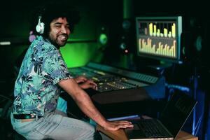 joven afro hombre trabajando en música grabación estudio - masculino audio ingeniero mezcla un sonido en producción casa foto