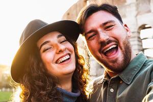 contento joven Pareja tomando selfie en frente de Roma coliseo durante vacaciones foto