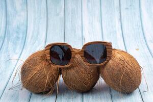 Tres todo cocos y de madera lentes en un azul de madera antecedentes foto