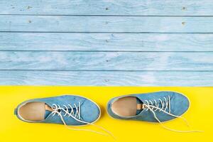 el azul Zapatos estar en un aislado mezclado azul y amarillo antecedentes foto