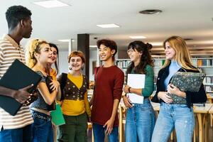 Young university students standing inside library - School education concept photo