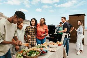Happy multigenerational people having fun doing barbecue grill at house rooftop - Summer gatherings and food concept photo