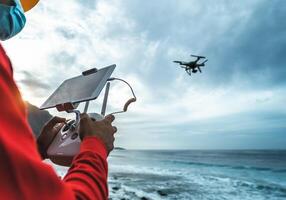 Male engineer doing inspection using drone while wearing face mask to avoid corona virus spreading - Technology and industrial concept photo