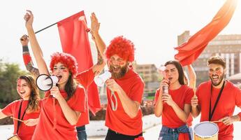 Football fans watching soccer match event at stadium - Young people having fun supporting favorite club - Sport entertainment concept photo