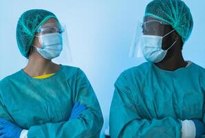 Doctors wearing personal protective equipment fighting against corona virus outbreak - Health care and medical workers concept photo