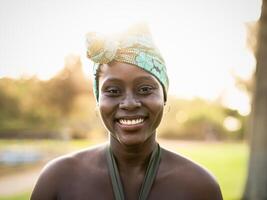 retrato de contento africano mujer vistiendo vistoso tradicional turbante - afro negro cultura y tradicion concepto foto