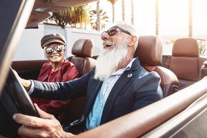 contento mayor Pareja teniendo divertido en nuevo convertible coche - maduro personas disfrutando hora juntos durante la carretera viaje vacaciones - mayor estilo de vida y viaje transporte concepto foto