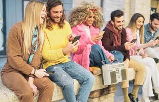 Group happy friends using mobile smartphones in the city - Millennial young people having fun with new trendy apps for social media notworks - Tech generation z and youth lifestyle culture concept photo