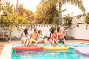 Happy friends making pool party taking selfie with mobile smartphone - Young millennial people having fun in exclusive tropical resort vacation - Summer holidays and youth people lifestyle photo