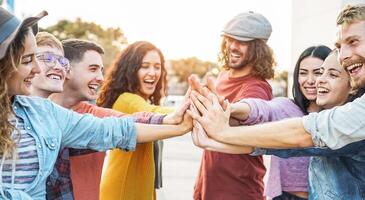 Young friends stacking hands outdoor - Happy millennial people having fun joining and celebrating together - Friendship, empowering, teamwork, partnership and youth lifestyle concept photo