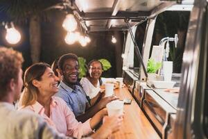 Happy multiracial people buying meal from food truck kitchen - Modern business and take away concept photo