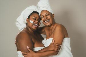 Happy African multigenerational women having skin care spa day - People wellness lifestyle concept photo