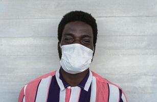 Young African man wearing face protective mask to avoid spread of corona virus pandemic - Health care and pandemic crisis concept photo