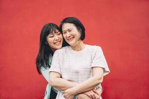 Happy Asian mother and daughter having fun outdoor - Chinese family people spending time together outside - Love, relationship and parenthood lifestyle concept photo