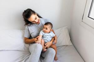 Happy mother lying in the bed with her little baby - Family and Maternity concept photo