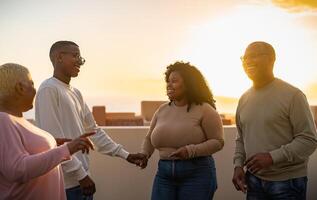 Happy African family having fun on rooftop during sunset time photo