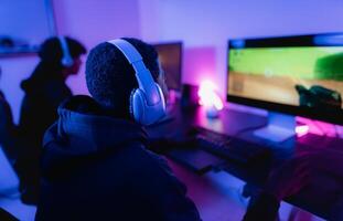 joven jugadores teniendo divertido jugando en línea vídeo juegos con computadora a hogar - juego de azar entretenimiento y tecnología concepto foto