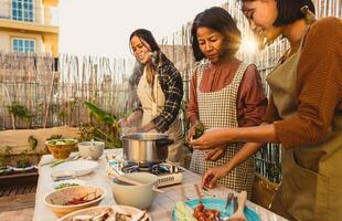 Sureste asiático madre con su hijas teniendo divertido preparando comida receta juntos a casa patio foto