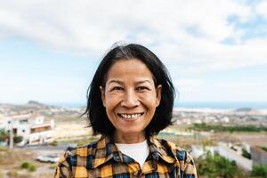 Happy Thai woman having fun having fun smiling into the camera at house rooftop photo