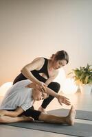 Mom and teenage daughter do gymnastics together in the fitness room. A woman and a girl train in the gym photo