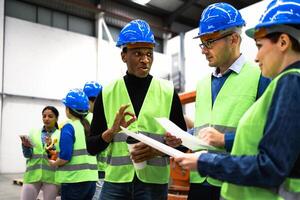 Team of multiracial engineers working in robotic factory - Tech industry concept photo