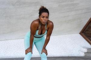 Young African woman taking a break during workout exercises outdoor - Sport people lifestyle concept photo