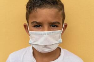 niño vistiendo cara protector máscara yendo espalda a colegio durante corona virus pandemia - la seguridad covid19 medidas concepto foto