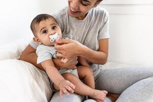 Happy mother having fun with her little baby on bed - Family and maternity concept photo