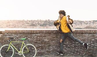Afro American man having fun dancing in city center - Happy young guy enjoying time a sunset outdoor - Millennial generation lifestyle and positive people attitude concept photo