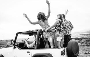 Group of friends driving off road convertible car during roadtrip - Happy travel people having fun in vacation - Friendship, transportation and youth lifestyle holidays concept photo