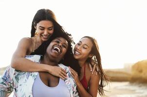 Happy multiracial friends having fun on the beach during summer holidays photo