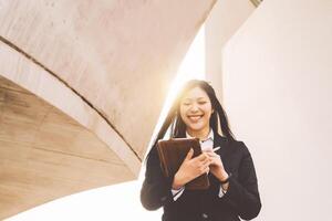 Asian business woman using smart tablet out office - Young smiling Chinese girl ready for working on digital marketing - Technology apprenticeship and entrepreneurship professional job concept photo