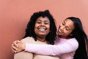 Happy Latin girls having fun embracing outdoor - Young people lifestyle and friendship concept photo