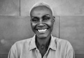 Happy Afro woman portrait - African senior female having fun smiling in front of camera - Black and white editing photo