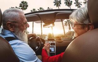 contento mayor Pareja teniendo divertido conducción en nuevo convertible coche - maduro personas disfrutando hora juntos durante la carretera viaje excursión vacaciones - mayor estilo de vida y viaje cultura transporte concepto foto