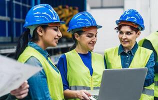 Diverse female engineers working in robotic factory - Tech industrial concept photo