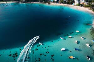 Aerial picture of the east coast of Mauritius Island. Beautiful lagoon of Mauritius Island shot from above. Boat sailing in turquoise lagoon photo